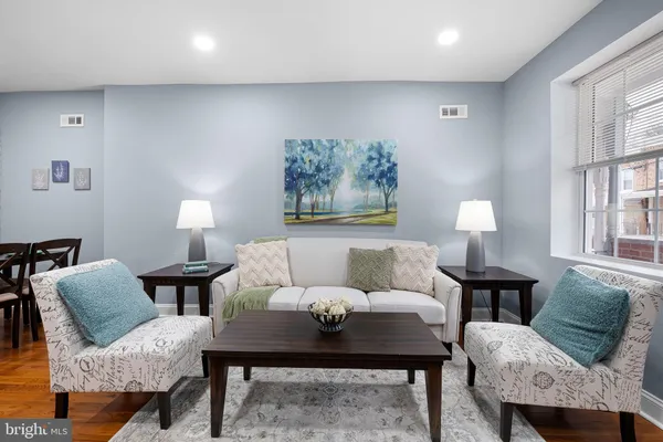 a living room with furniture a window and a lamp