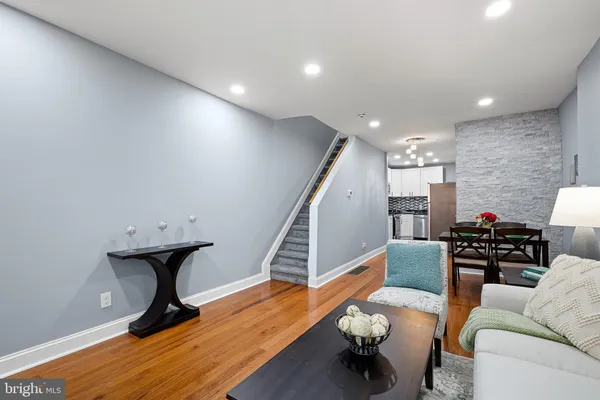 a living room with furniture and wooden floor