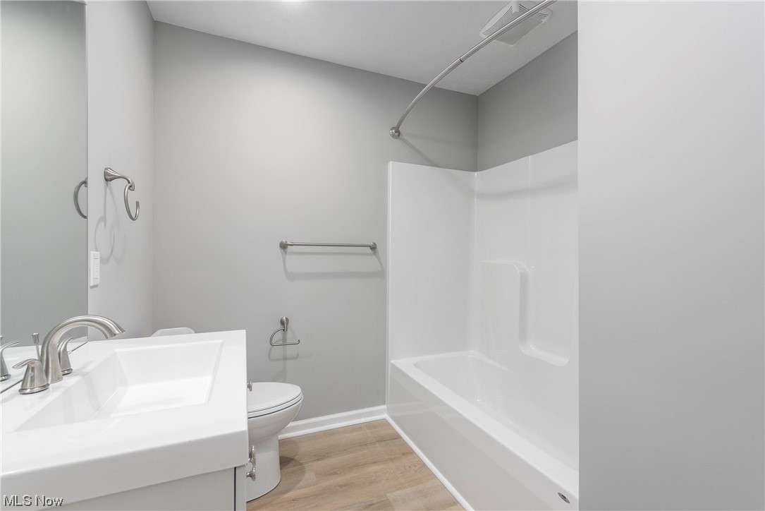 317 Substation Road Brunswick, OH 44212 - Photo 29 of 36 Full bathroom featuring hardwood / wood-style floors, shower / washtub combination, vanity, and toilet