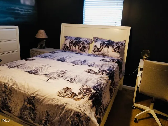 a bed sitting in a bedroom next to a window