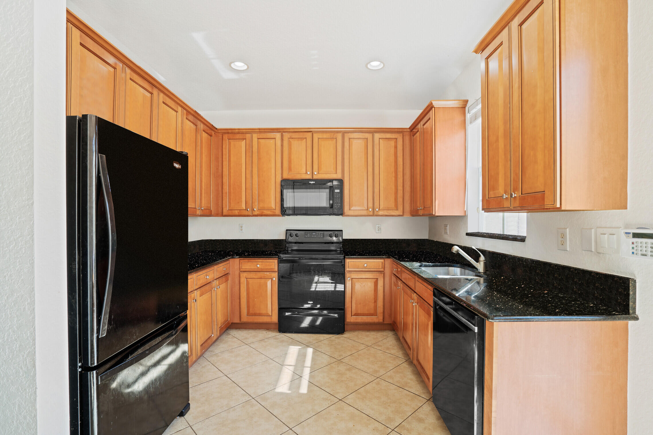 151 Mulligan Place Jupiter, FL 33458 - Photo 7 of 23 a kitchen with granite countertop stainless steel appliances a refrigerator a stove a sink and a window