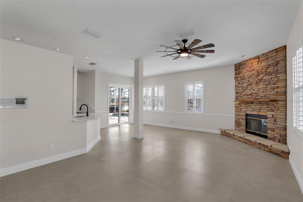2626 Raccoon Run Lane Orlando, FL 32837 - Photo 11 of 62 wooden floor in an empty room with a fireplace