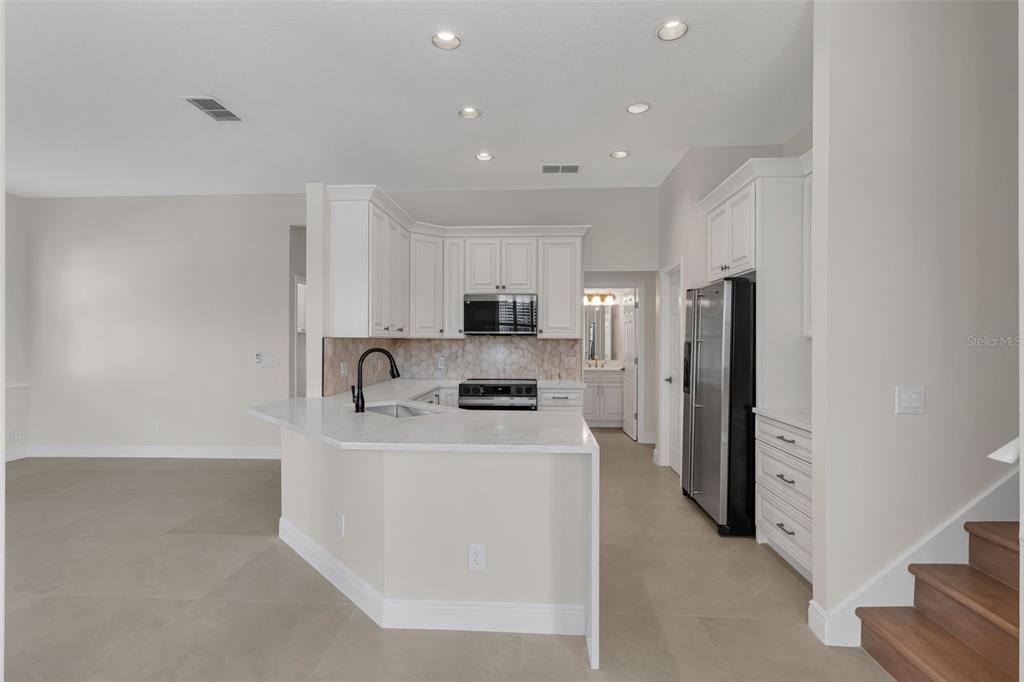 2626 Raccoon Run Lane Orlando, FL 32837 - Photo 18 of 62 a kitchen with stainless steel appliances granite countertop a refrigerator sink stove and oven