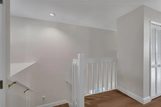 an empty room with wooden floor ceiling fan and windows