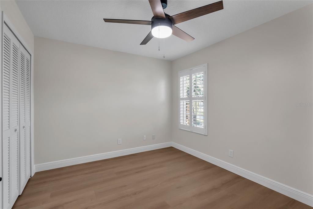 2626 Raccoon Run Lane Orlando, FL 32837 - Photo 38 of 62 an empty room with wooden floor ceiling fan and windows