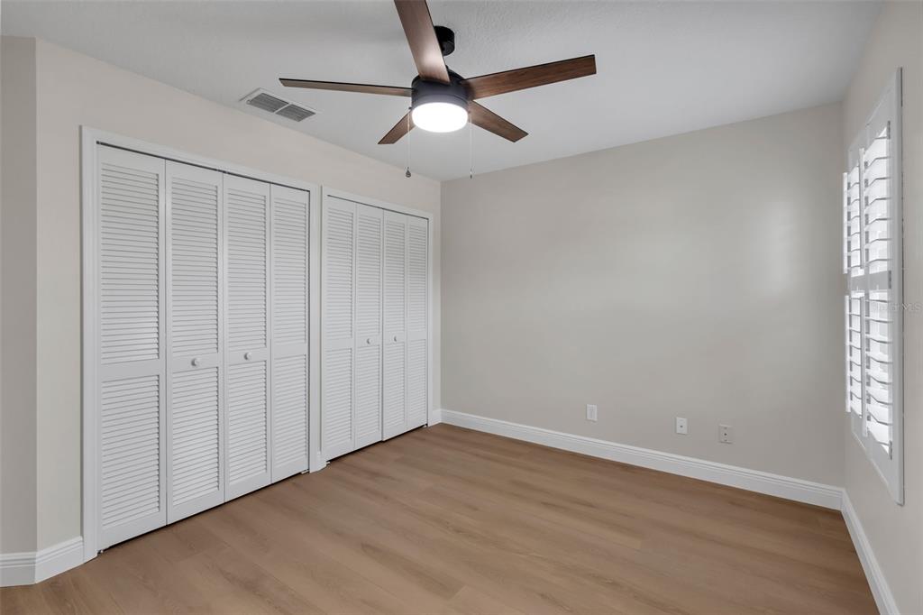 2626 Raccoon Run Lane Orlando, FL 32837 - Photo 39 of 62 an empty room with wooden floor fan and windows