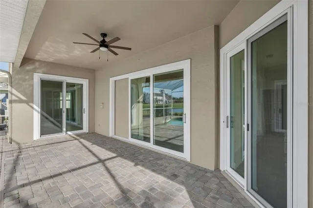 a view of a patio with a table chairs and a floor to ceiling window