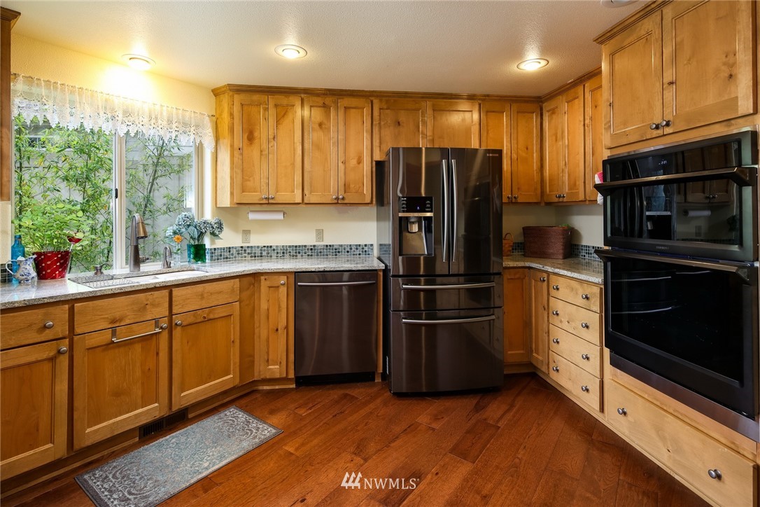 8 Inlet Circle Bellingham, WA 98229 - Photo 11 of 39 a kitchen with granite countertop stainless steel appliances a refrigerator cabinets and a sink