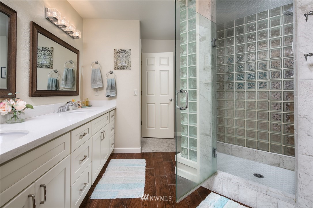 8 Inlet Circle Bellingham, WA 98229 - Photo 18 of 39 a bathroom with a double vanity sink a large mirror and shower