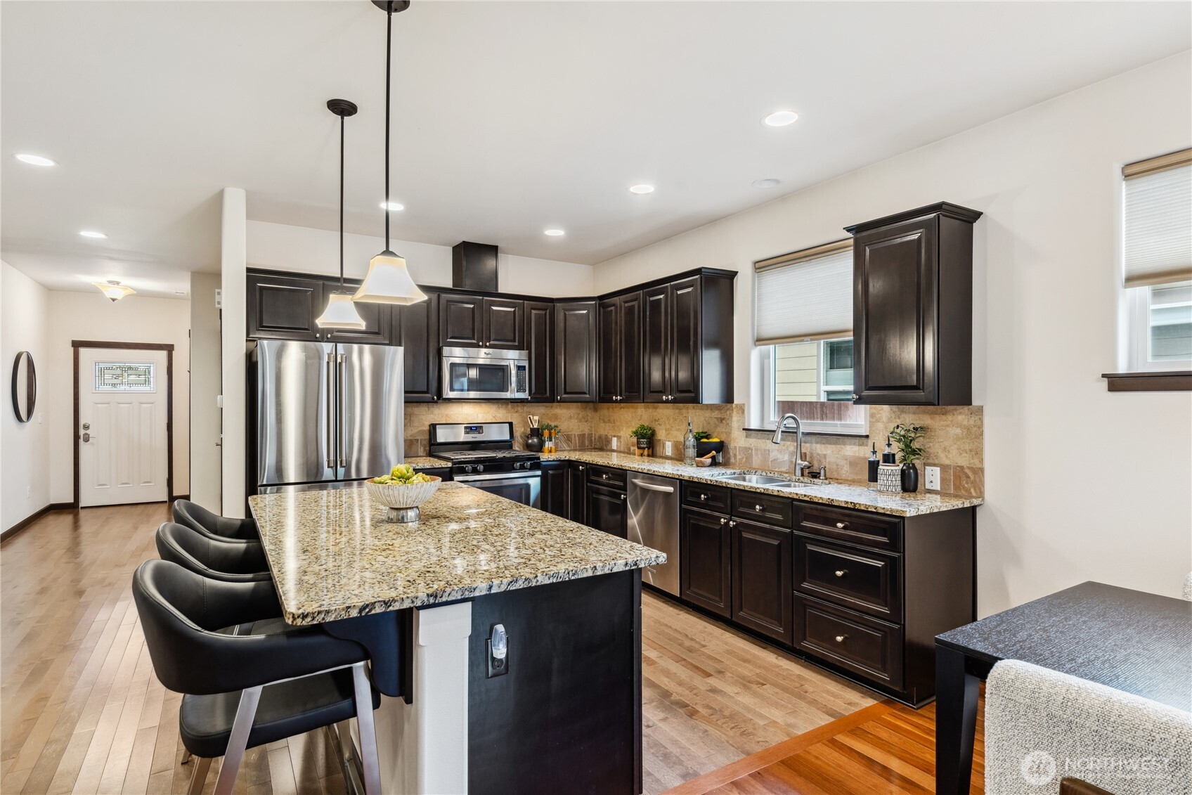 1886 Silver Loop Mount Vernon, WA 98274 - Photo 4 of 36 a kitchen with stainless steel appliances kitchen island granite countertop a stove top oven a sink dishwasher a dining table and chairs with wooden floor