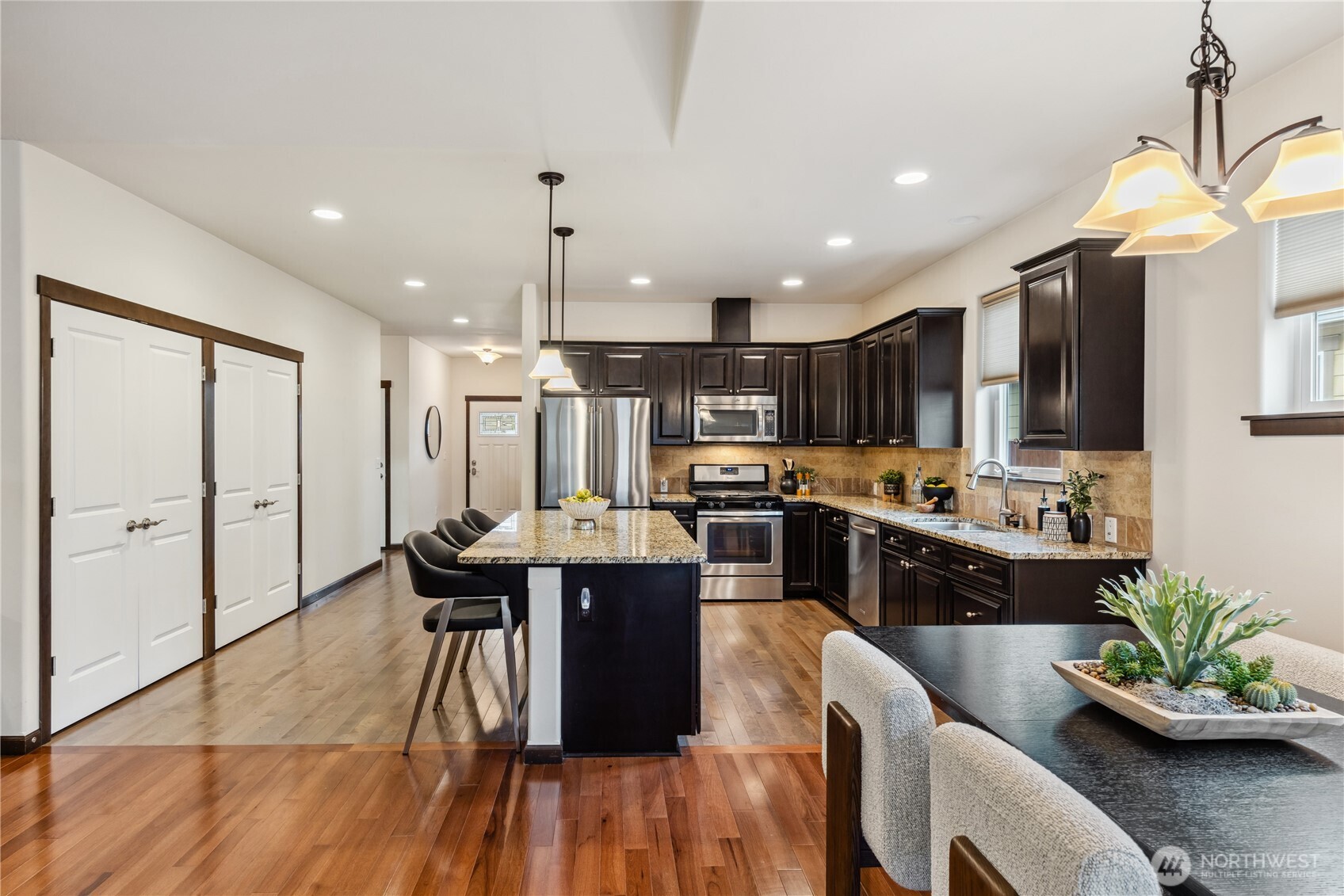 1886 Silver Loop Mount Vernon, WA 98274 - Photo 8 of 36 a kitchen with stainless steel appliances kitchen island granite countertop a table chairs and a refrigerator
