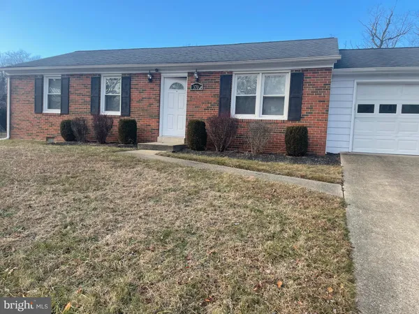 front view of a brick house with a yard