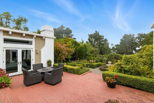 a view of a patio with couches table and chairs and potted plants