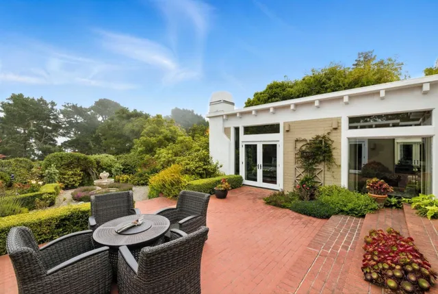 a view of a patio with couches table and chairs and potted plants
