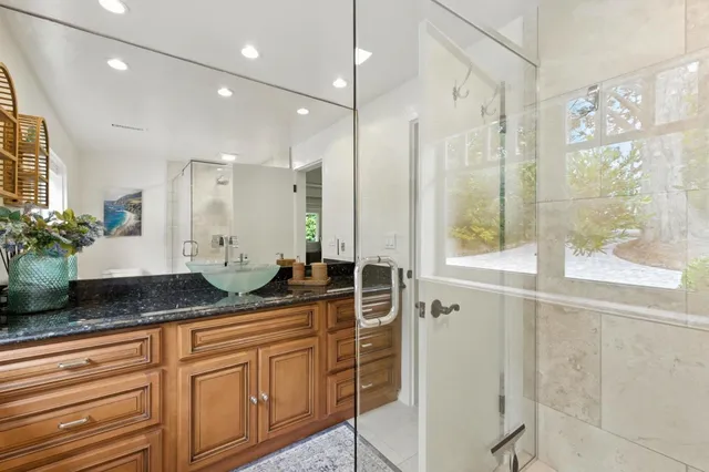 a bathroom with a granite countertop sink and a mirror