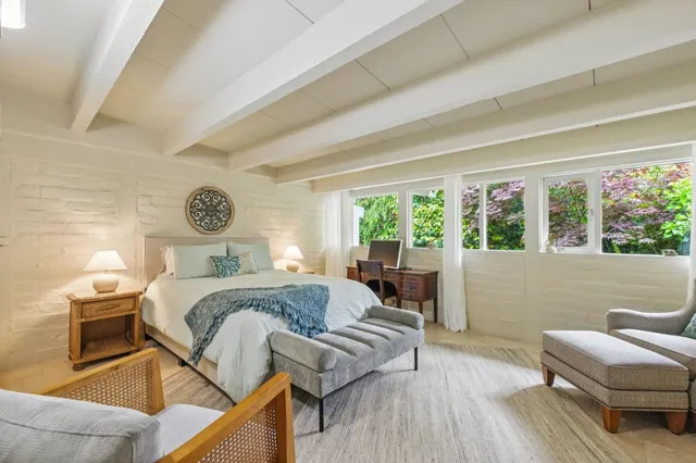 a bedroom with a bed and a large window