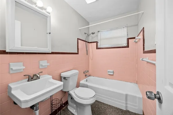 a white toilet sitting next to a white sink and vanity