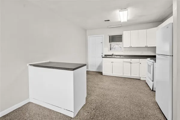 a kitchen with granite countertop white cabinets and white appliances