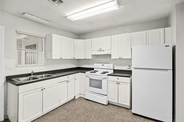 a kitchen with white cabinets and white appliances