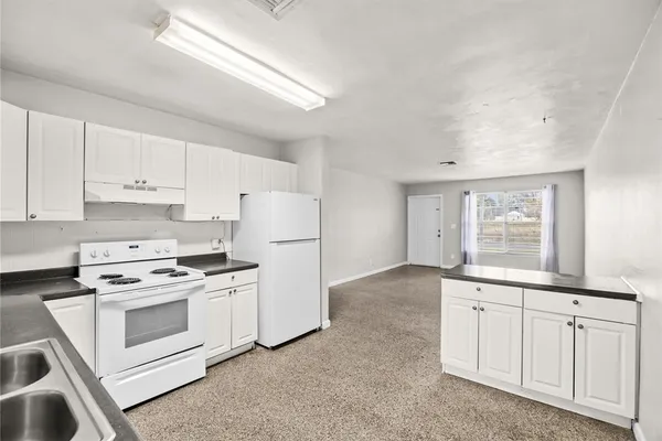 a kitchen with white cabinets and white appliances