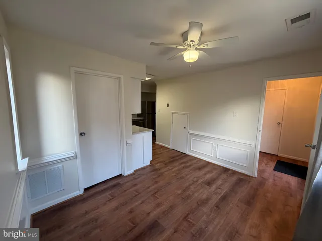 a view of a livingroom with wooden floor and an empty space
