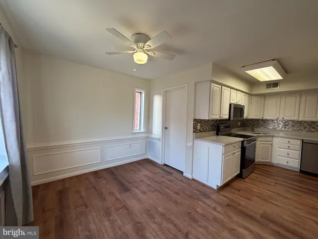a kitchen with a refrigerator and white cabinets