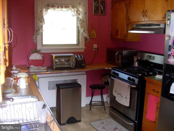 604 Charing Cross Road Baltimore, MD 21229 - Photo 2 of 13 a view of a kitchen with a fireplace and a window
