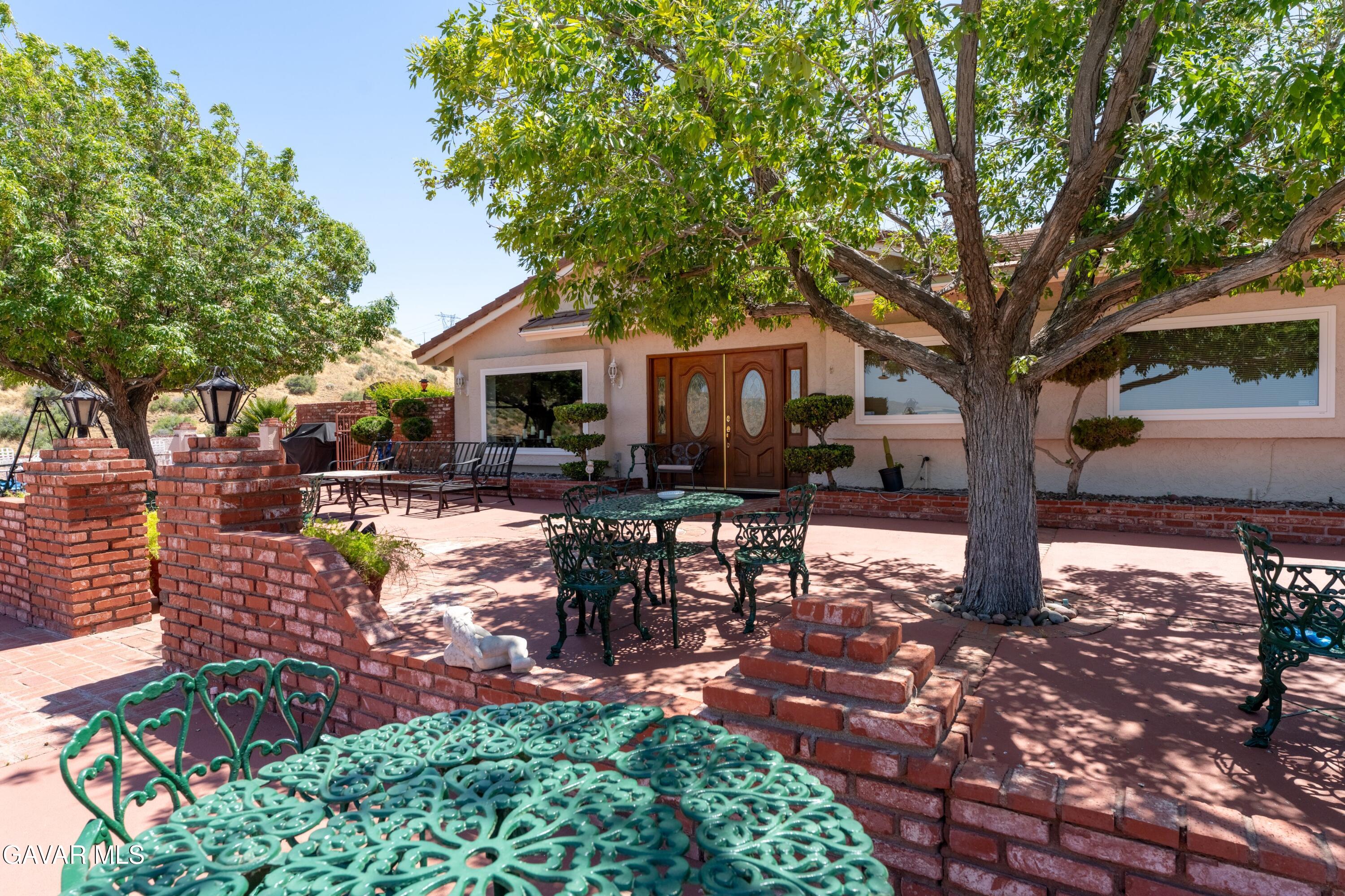 5801 Hacienda Ranch Road Palmdale, CA 93551 - Photo 12 of 69 a patio with sofas table and chairs with plants and trees