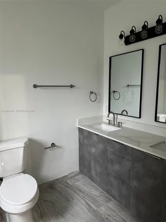 a bathroom with a toilet sink and mirror