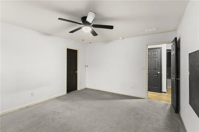 an empty room with closet and windows