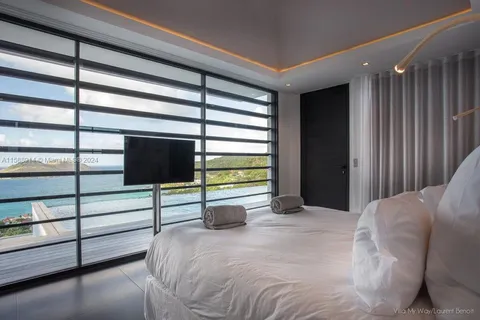 a large bedroom with a large bed and large windows