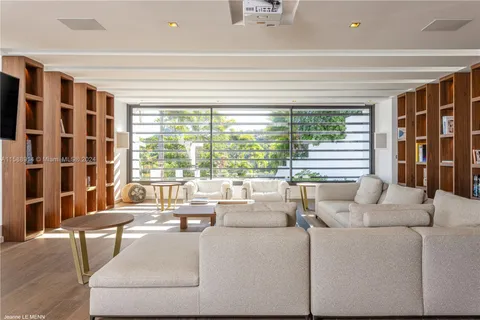 a living room with furniture and a floor to ceiling window