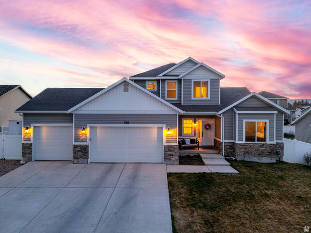 836 South 250 West Vernal, UT 84078 - Photo 2 of 56 View of front facade featuring stone siding, a garage, roof with shingles, concrete driveway, and a gate