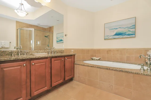 a bathroom with a granite countertop sink a large mirror and a bathtub