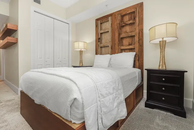 a bedroom with a bed a flat tv screen and a window