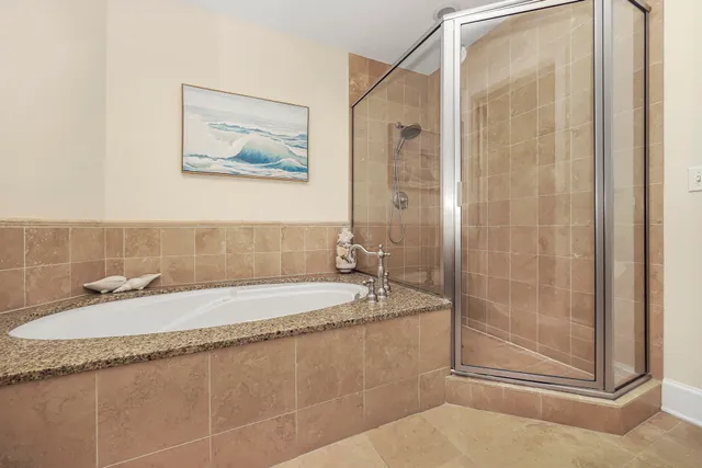 a bathroom with a granite countertop sink a mirror and a shower