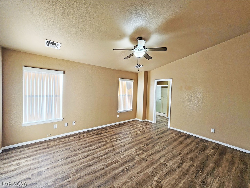 3680 Ravine Avenue Pahrump, NV 89048 - Photo 12 of 28 Empty room featuring ceiling fan, baseboards, dark wood-style flooring, and visible vents