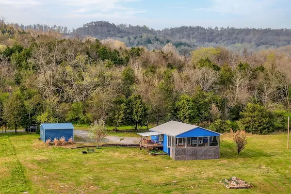 an aerial view of a house with swimming pool and mountains