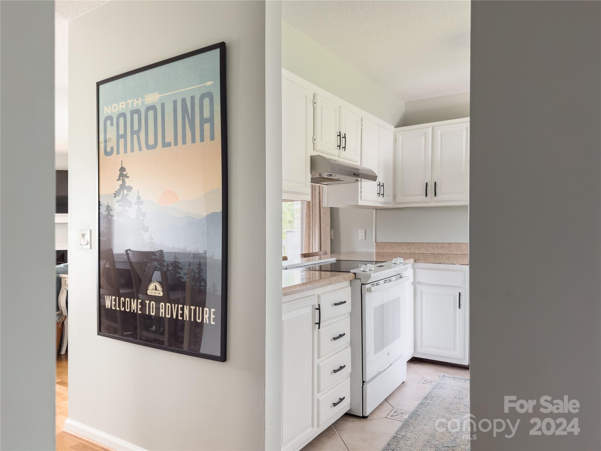 907 Victory Trail Morganton, NC 28655 - Photo 3 of 32 a kitchen with stainless steel appliances granite countertop a stove a refrigerator and white cabinets