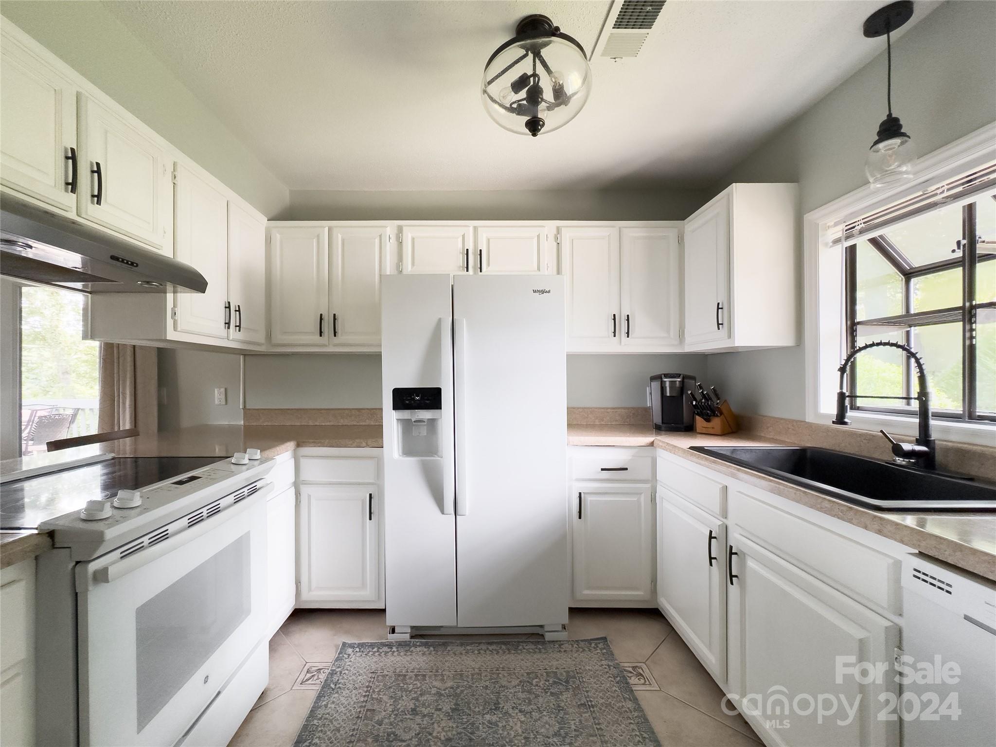 907 Victory Trail Morganton, NC 28655 - Photo 4 of 32 a kitchen with a sink cabinets stainless steel appliances and a window