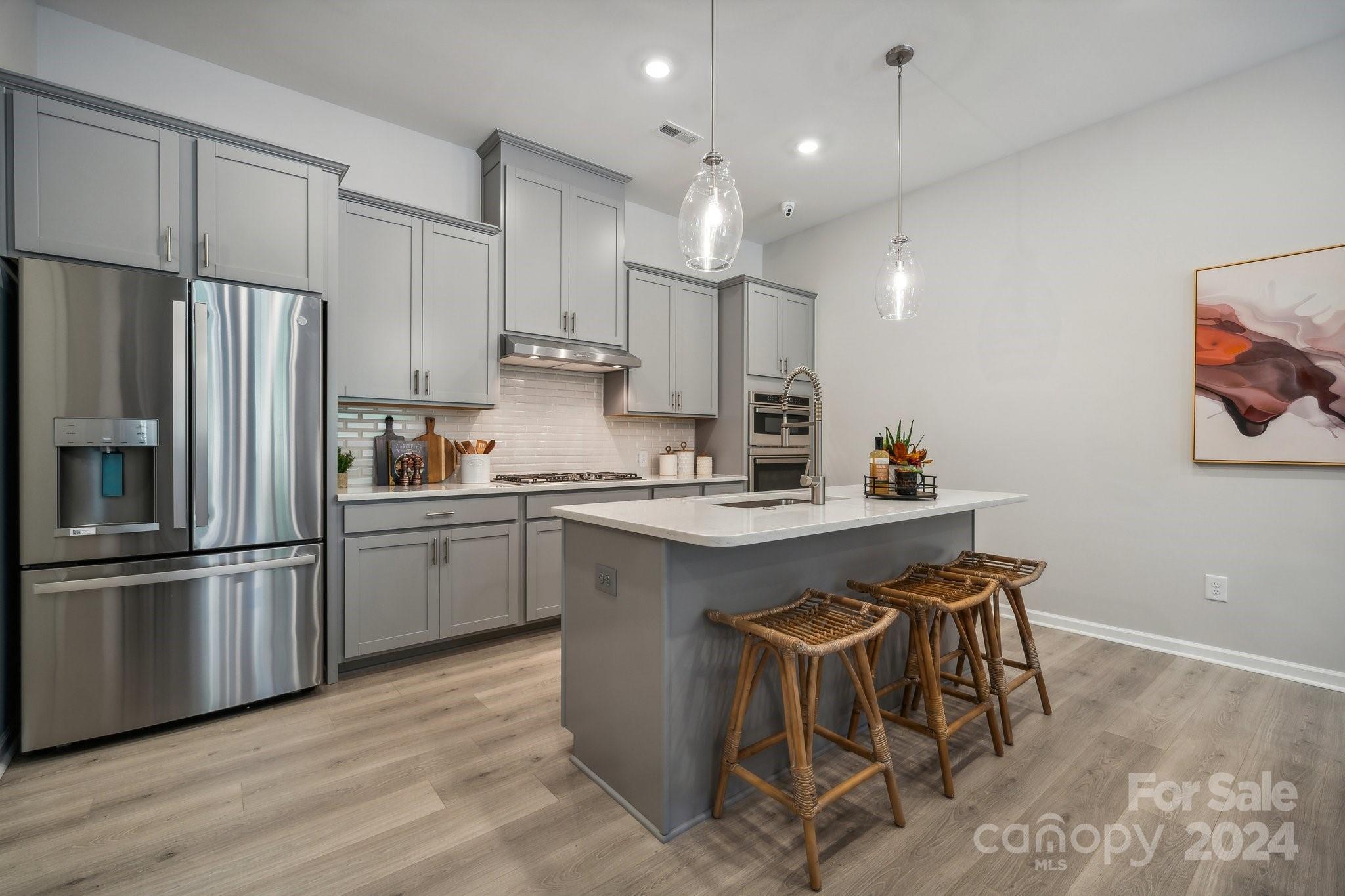 1186 Lost Cv Road Indian Land, SC 29707 - Photo 1 of 30 a kitchen with stainless steel appliances granite countertop a sink a stove a refrigerator and white cabinets with wooden floor