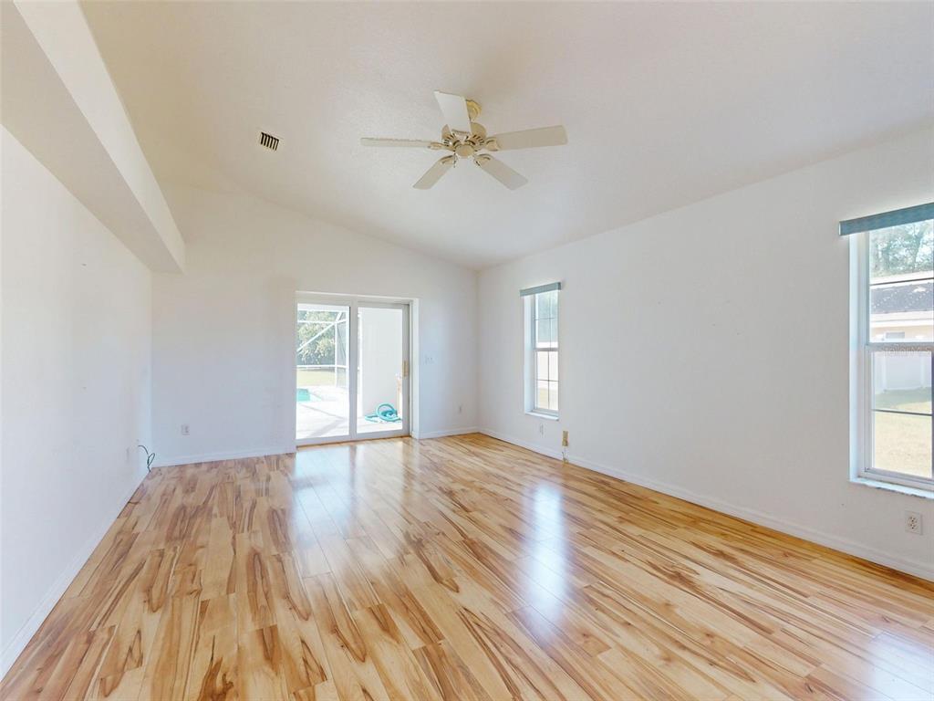 7558 Southwest 103rd Loop Ocala, FL 34476 - Photo 12 of 38 a view of an empty room with wooden floor and a window
