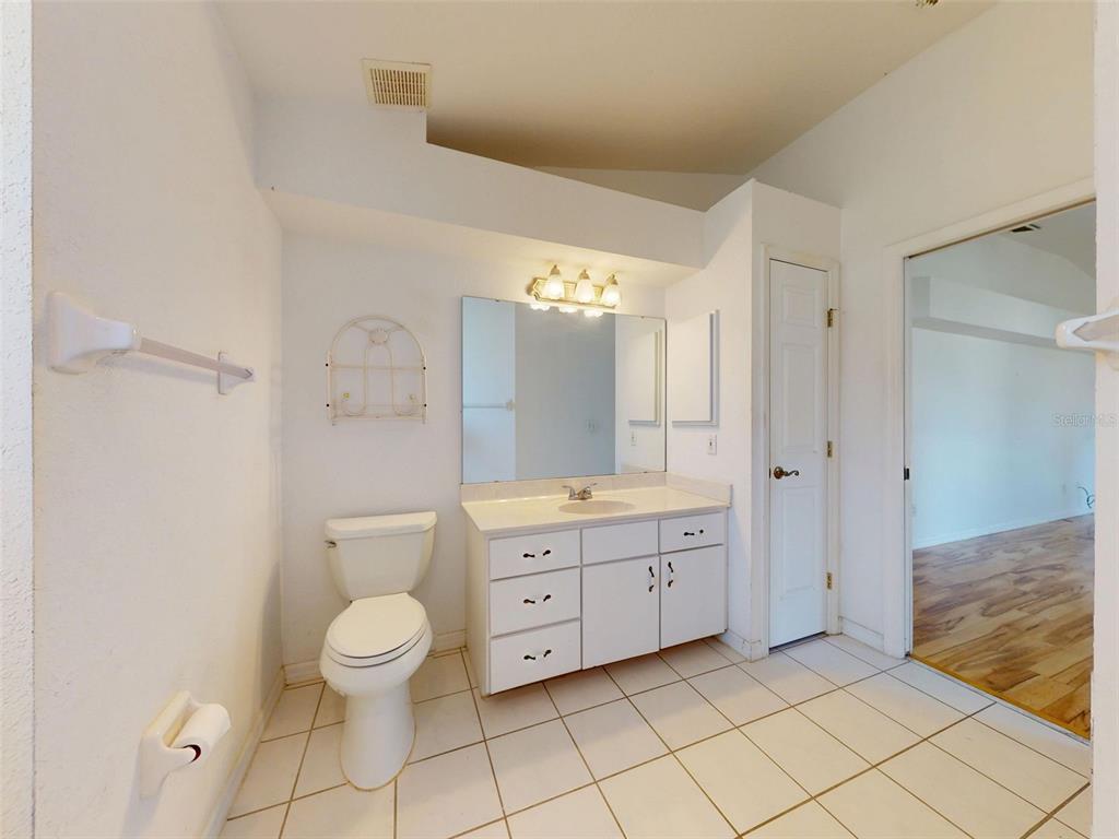 7558 Southwest 103rd Loop Ocala, FL 34476 - Photo 16 of 38 a spacious bathroom with a granite countertop toilet a sink and a mirror