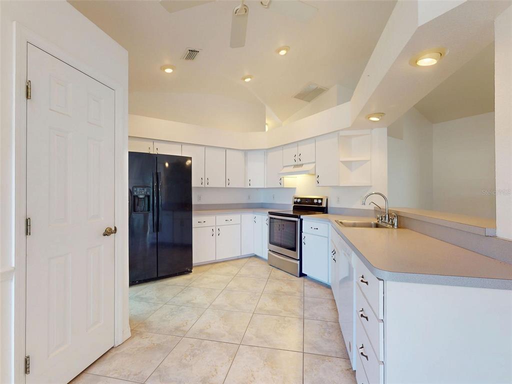 7558 Southwest 103rd Loop Ocala, FL 34476 - Photo 5 of 38 a large white kitchen with a sink and cabinets