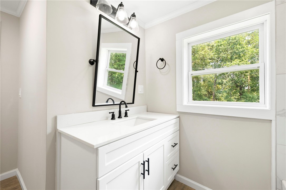 418 Old River Road Pelzer, SC 29669 - Photo 14 of 29 A well-lit primary bathroom vanity with a clear window offering tranquil outdoor views.