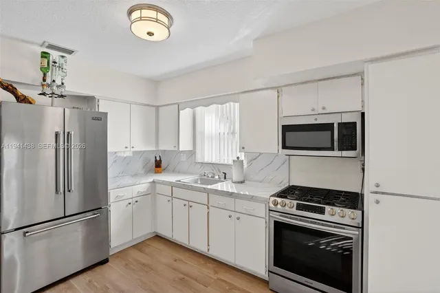 a kitchen with a sink stainless steel appliances and cabinets