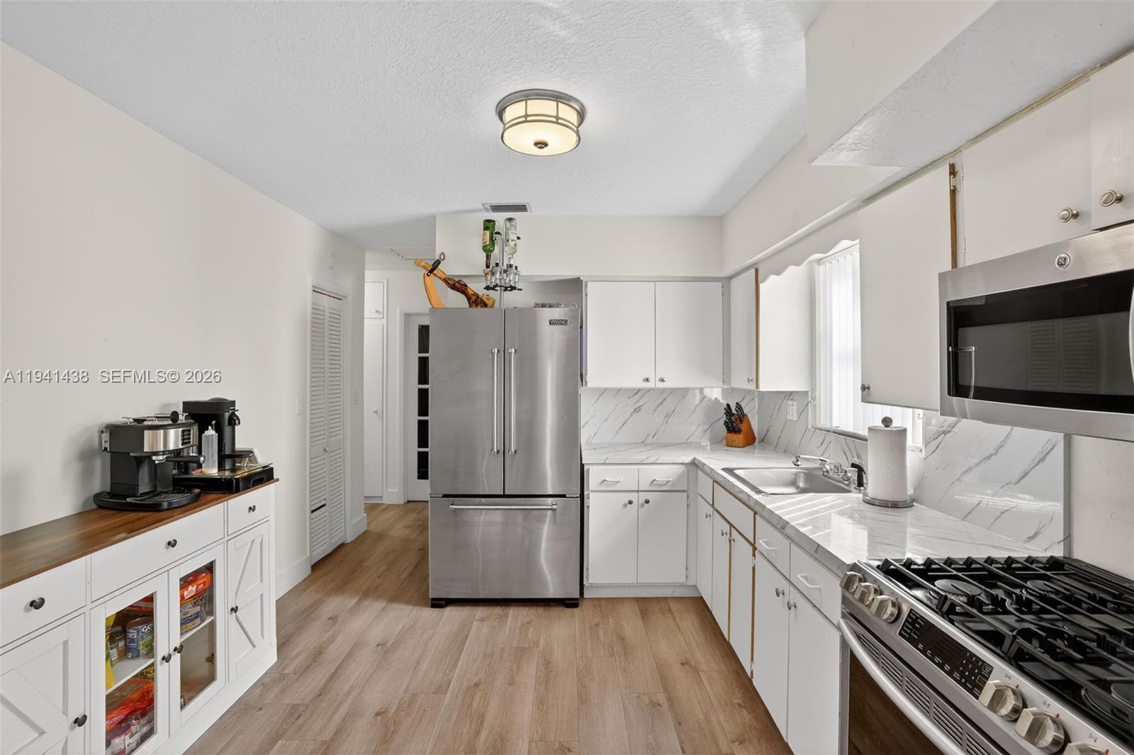 8500 Southwest 16th Street Miami, FL 33155 - Photo 10 of 26 a kitchen with a refrigerator and a stove top oven