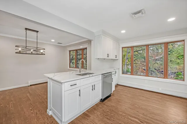 a kitchen with a stove a sink and wooden floor