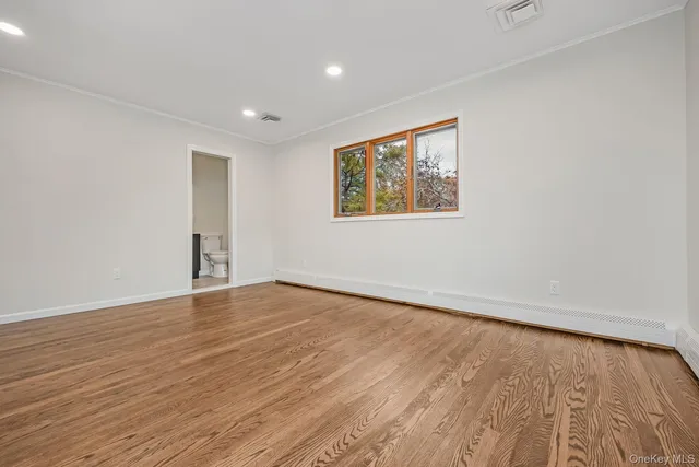 a view of empty room with fireplace and wooden floor