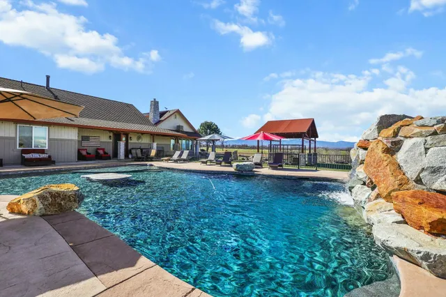 a living room with furniture a flat screen tv and a chandelier